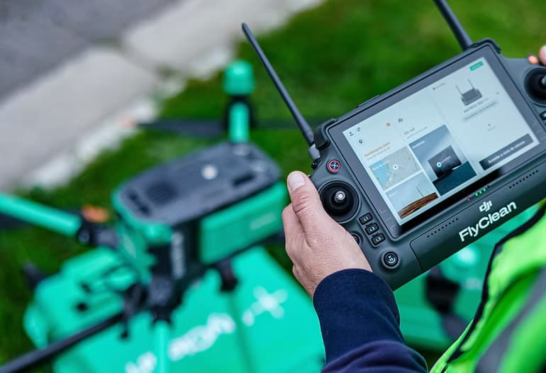 Drone de FlyClean realizando limpieza en fachada de edificio en altura